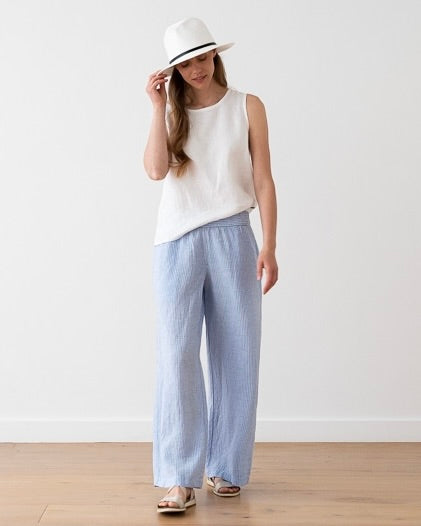 Model wearing LinenMe Ruth Trousers in light blue medium stripes color on a white background