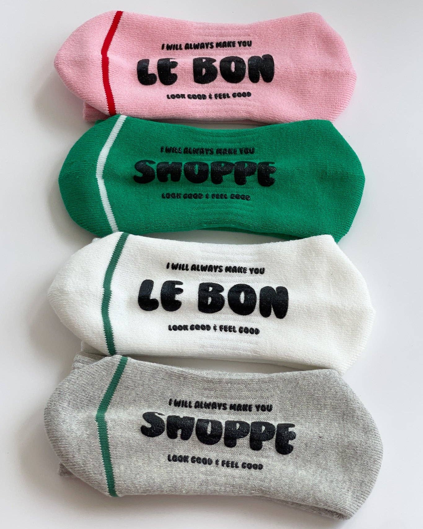 Four pairs of socks in pink, green, white, and gray with text on a white background