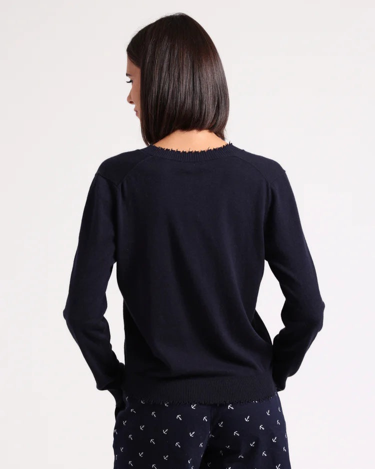 Person wearing a navy long-sleeve top and navy shorts with white patterns on a white background