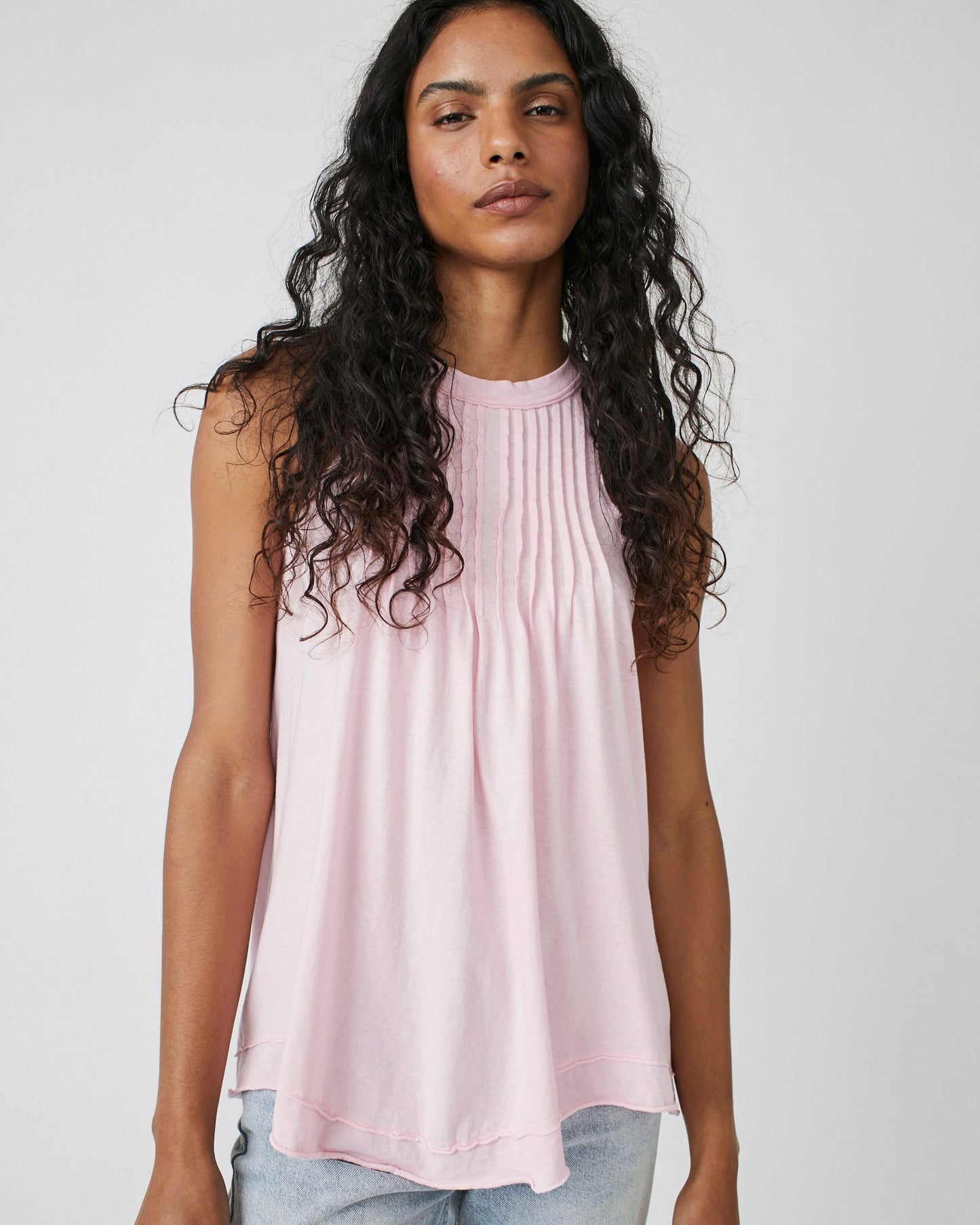 Model wearing Free People Go To Town Tank in Pink Lemon color wearing jeans on a white background