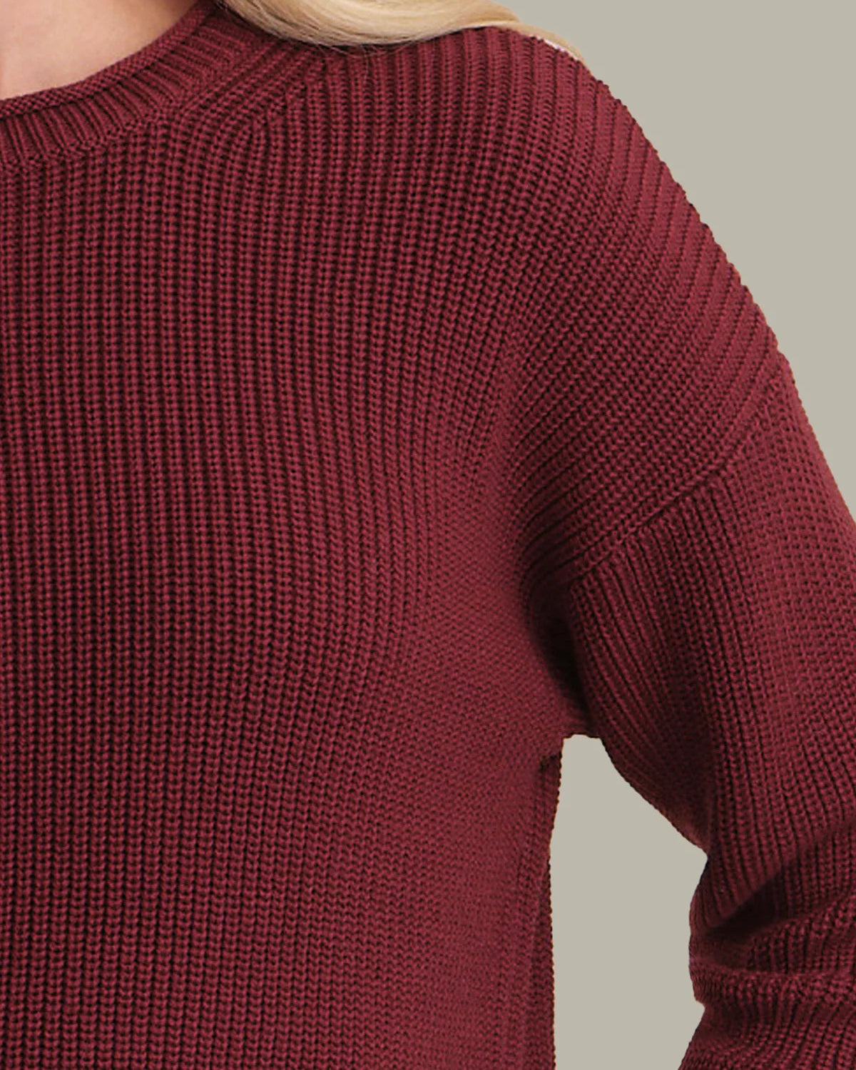 Close-up of a maroon sweater on a neutral background