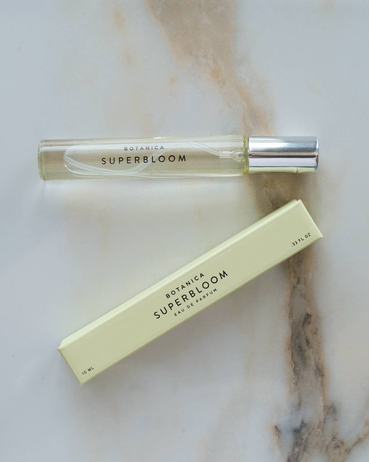 Botanica Super Bloom perfume bottle and packaging on a marble surface