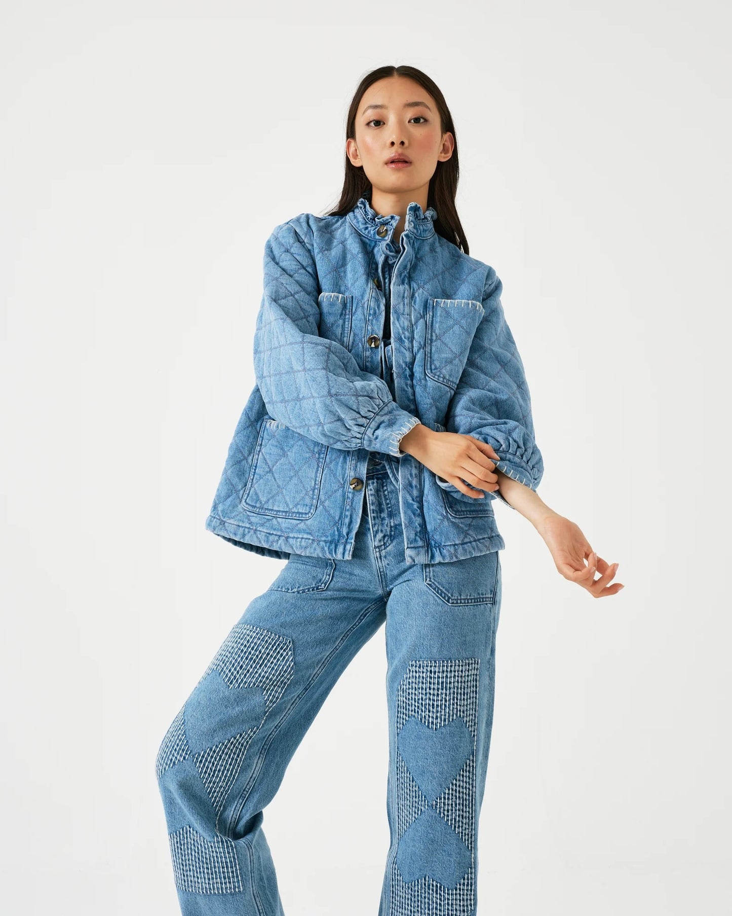 Model is wearing seventy + mochi Quilted Pablo Jacket in color rodeo vintage with light wash textured jeans on a white background