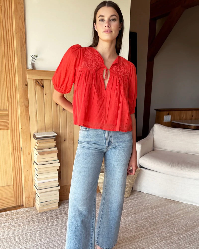 Model wearing Emerson Fry Grenadine Puff Isla Top wearing jeans standing in her house