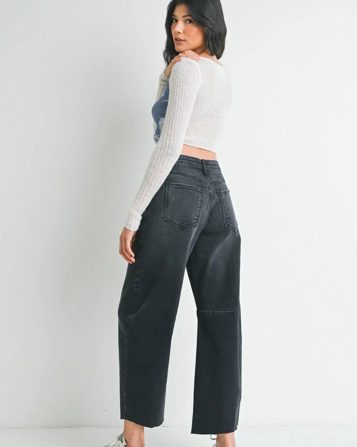 Person turned around wearing the Just Black Denim Barrel Seamed jeans in midnight against a white background.