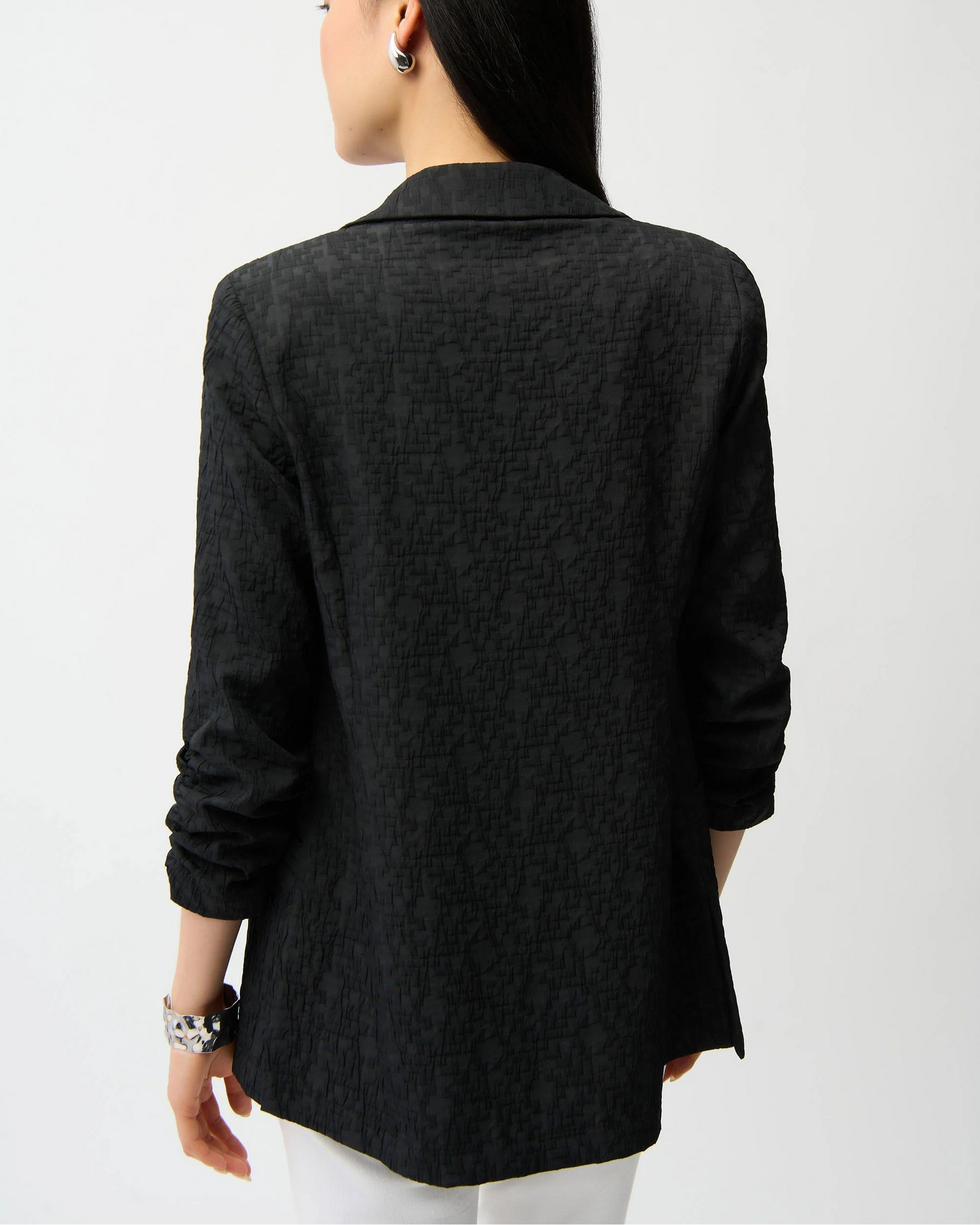 Person wearing a black blazer from behind on a white background