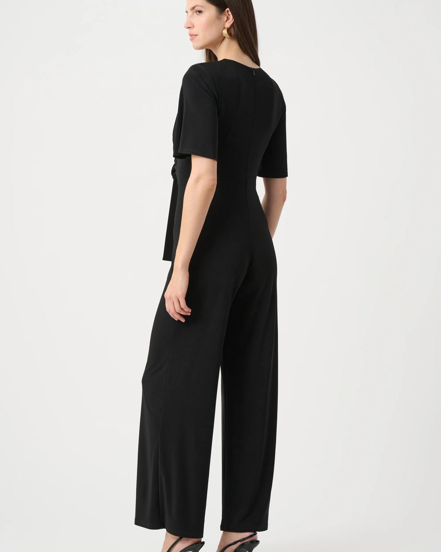 Woman wearing a black jumpsuit on a white background