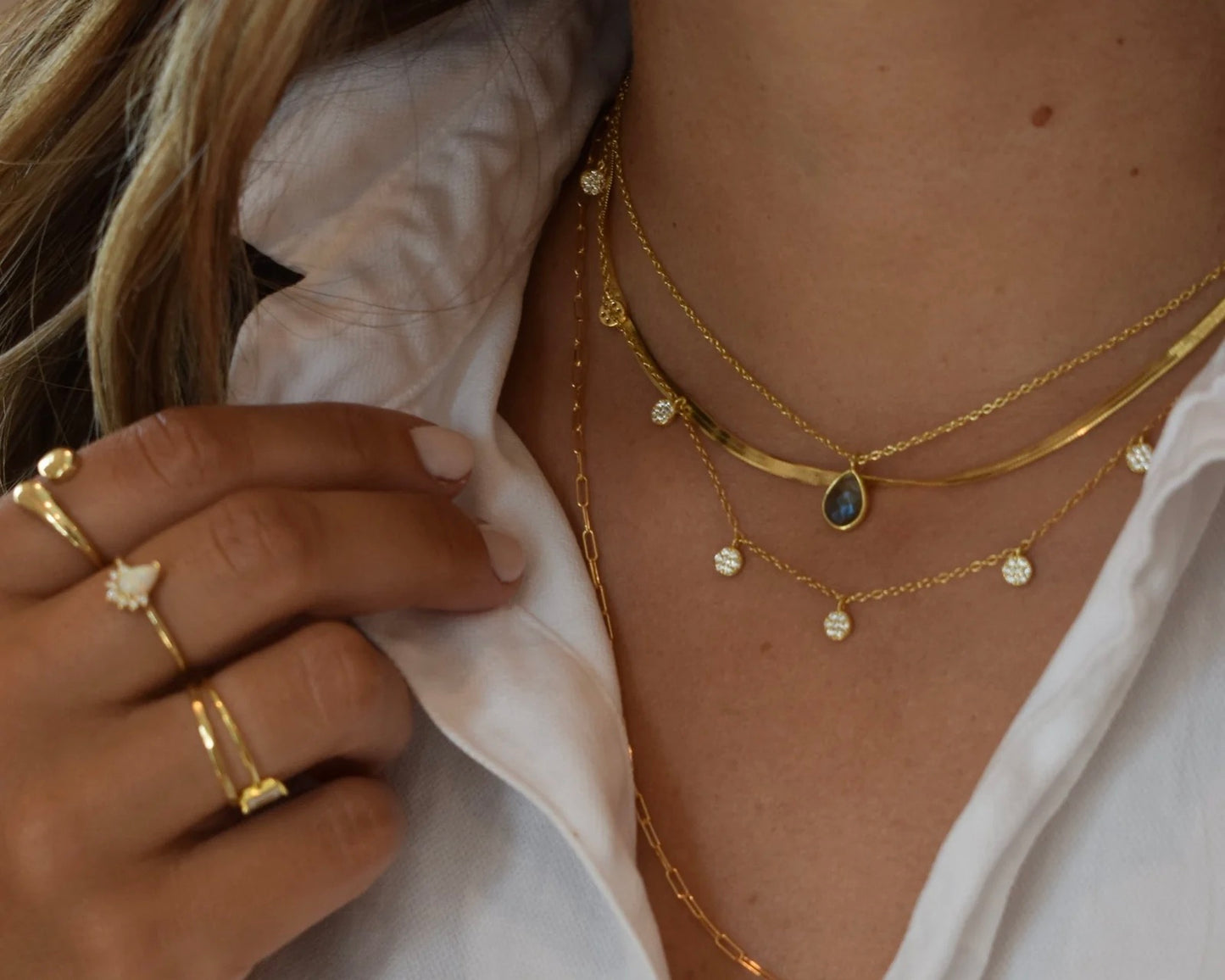 Close up photo from the front of the Elli Parr coin necklace in gold being worn around a neck