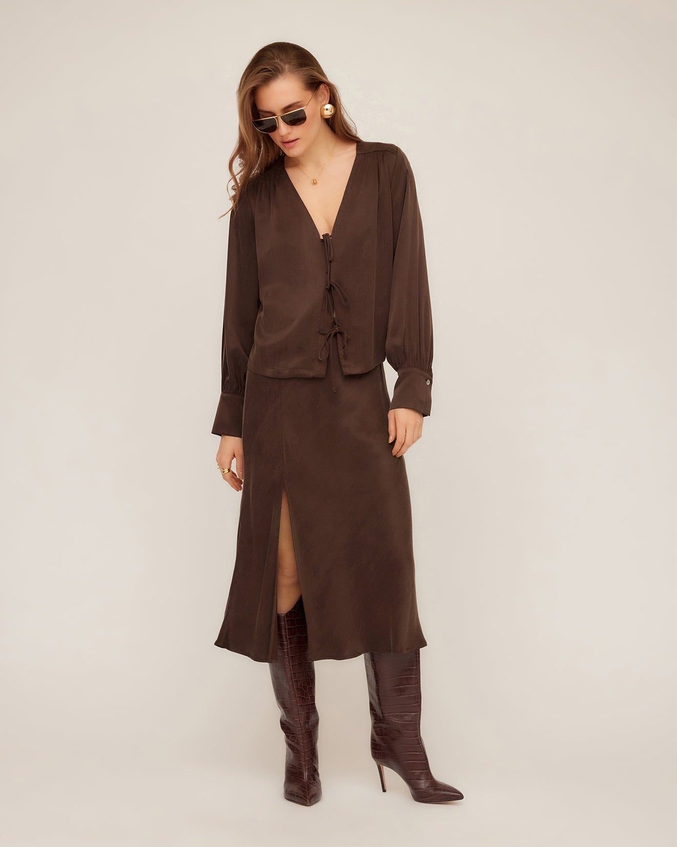 Model is wearing Fifteen Twenty Brielle Midi Skirt in color Brown on a white background.