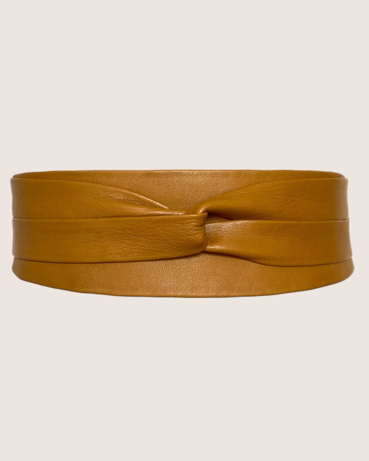 Tan leather belt on a beige background