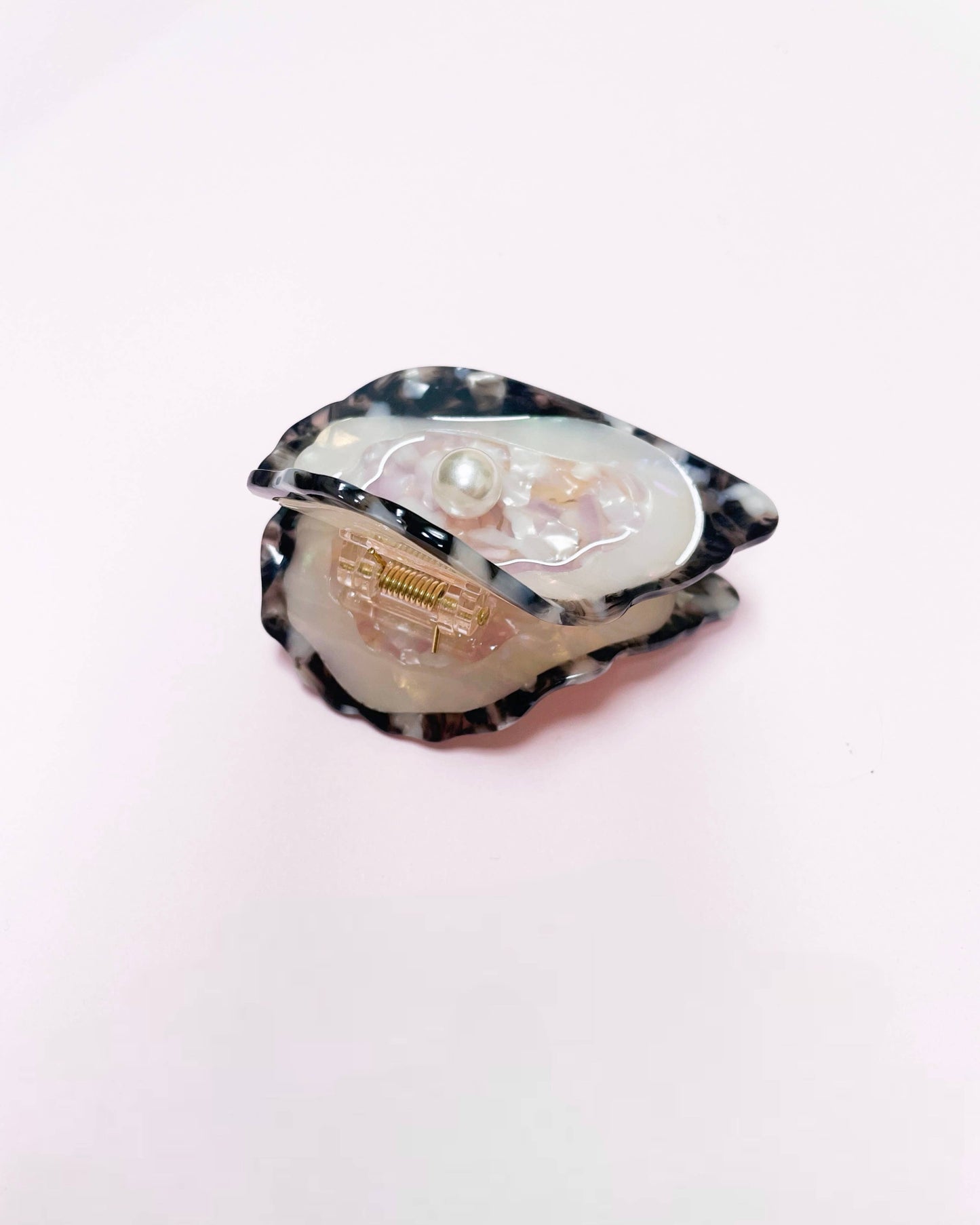 Side view of an oyster hair clip resting on a white background
