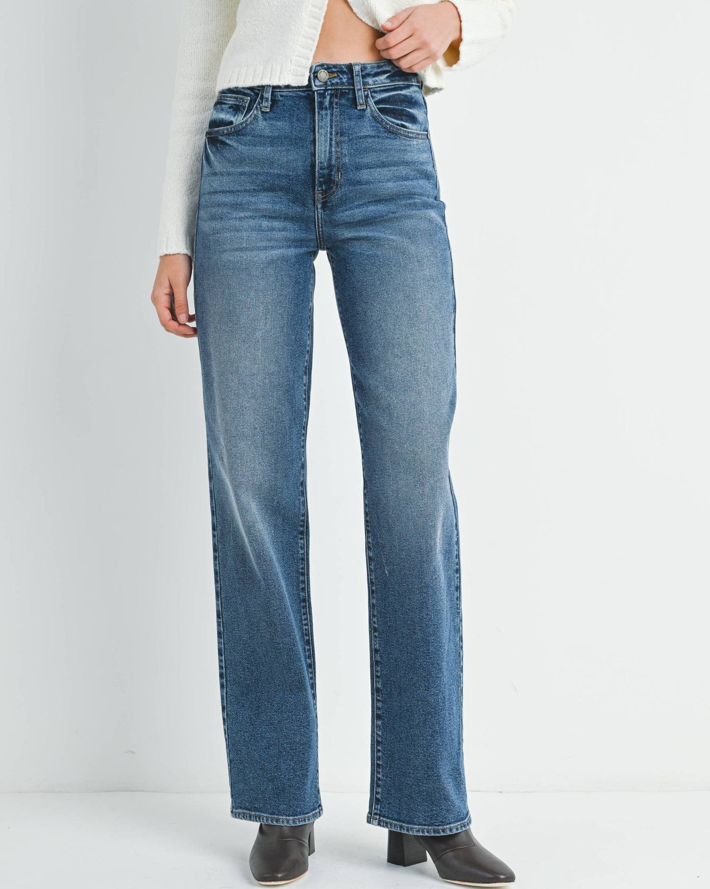 Person wearing blue jeans on a white background