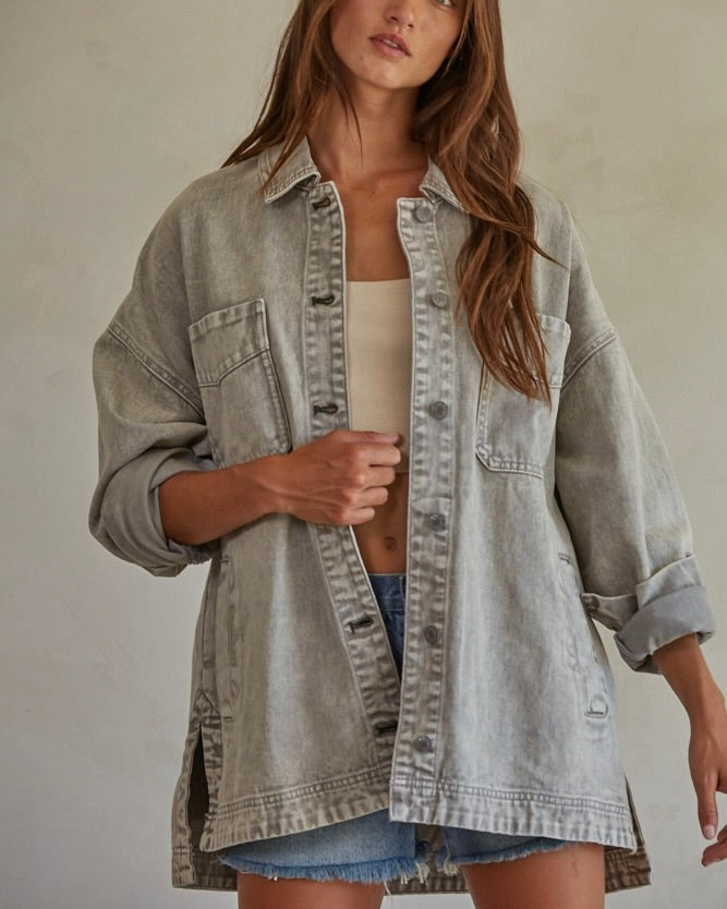 Close up front view of model wearing the By Together Woven 100% Cotton Washed Denim Jacket in front of a beige wall.