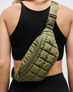 sol and selene resurgence belt bag, army green quilted shoulder or belt bag or fanny pack, on model with black top in front of white wall