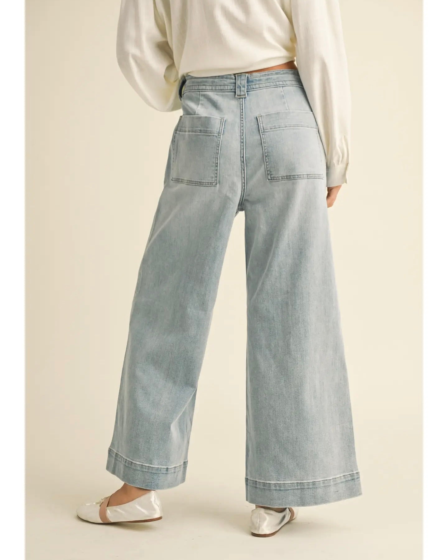 Model is wearing MIOU MUSE Washed Denim Tie Front Pants on a light beige background.