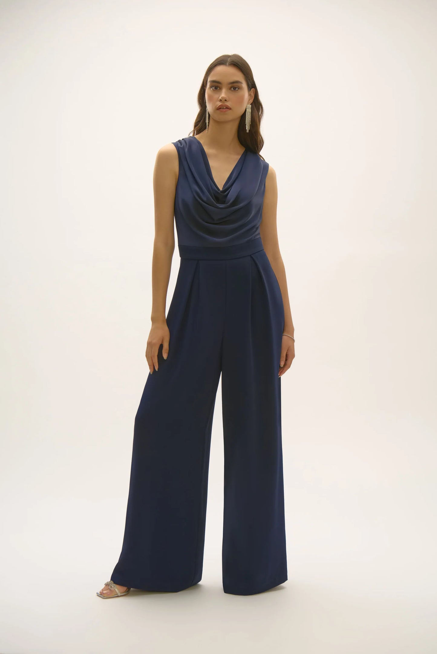 joseph ribkoff satin and crepe jumpsuit navy blue on model in front of white wall or background, wearing heels