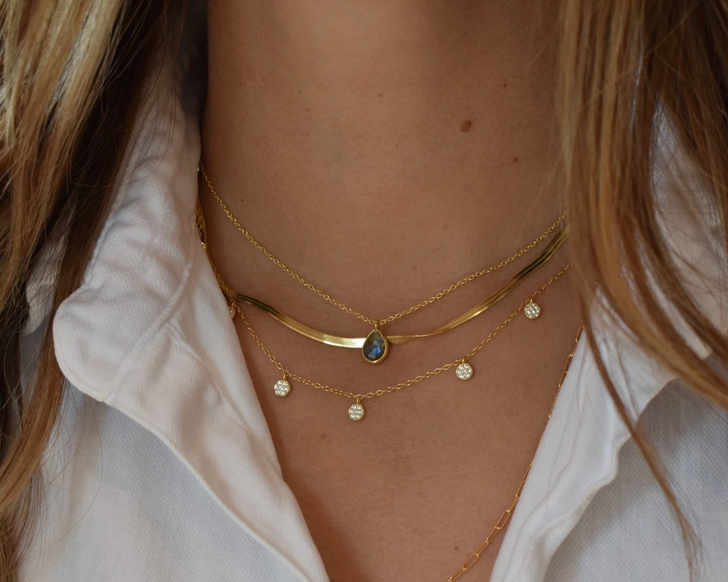 Close up photo of the Elli Parr coin necklace in gold being worn around a neck