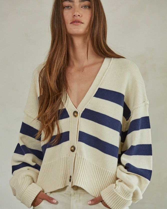 Close up front view of model wearing the By Together Knit Sweater Striped Button Down Cardigan against a beige wall