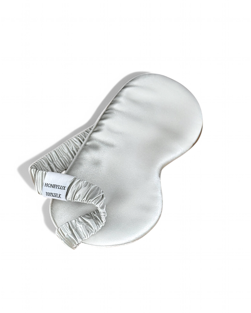 A silky silver HoneyLux eye mask on a white background