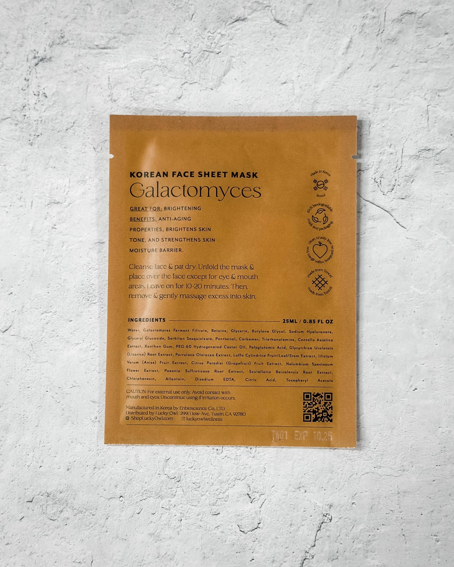 Korean face sheet mask packaging with text and QR code on a textured gray background