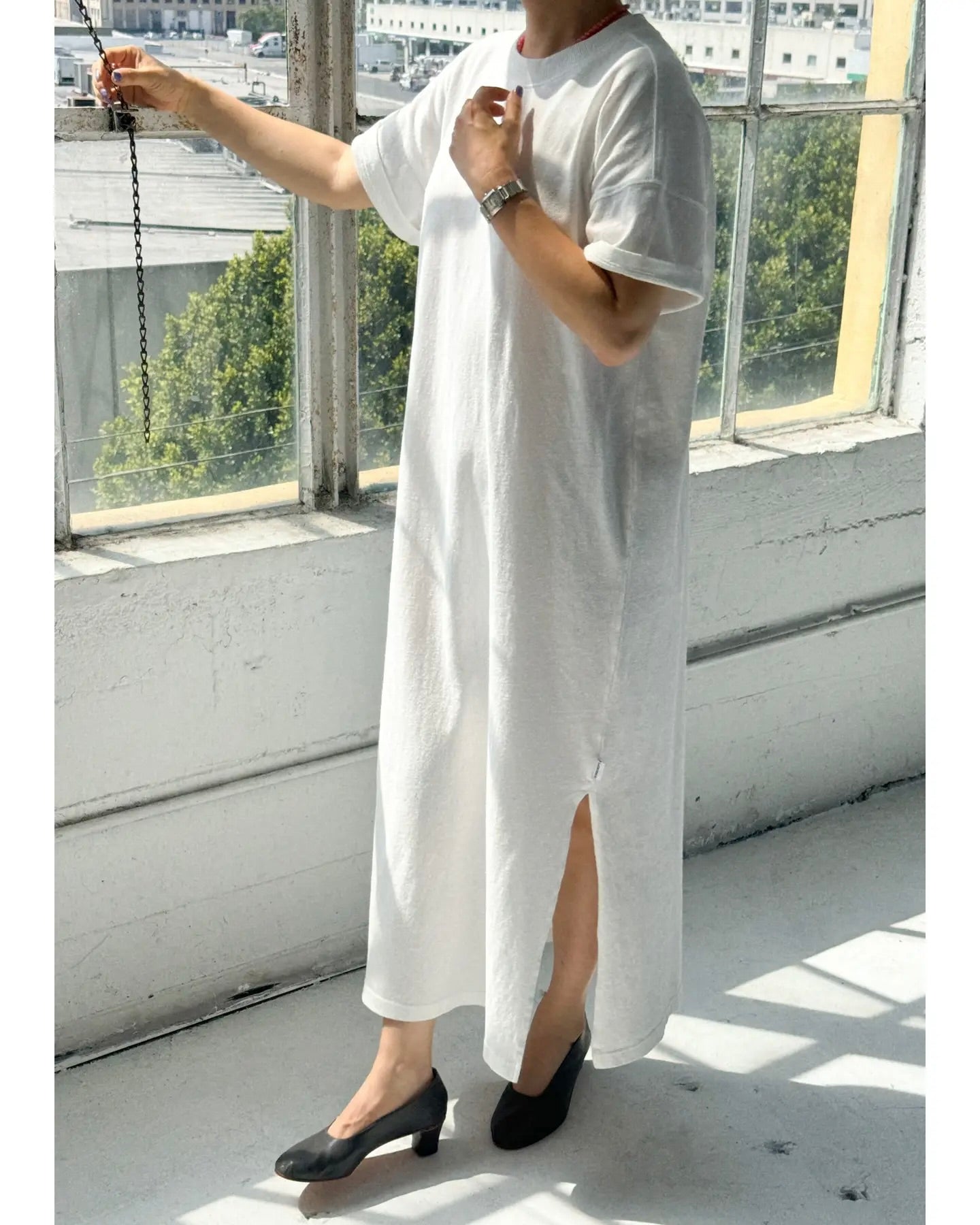 Side view of model wearing the Le Bon Shoppe Her Dress standing next to a window