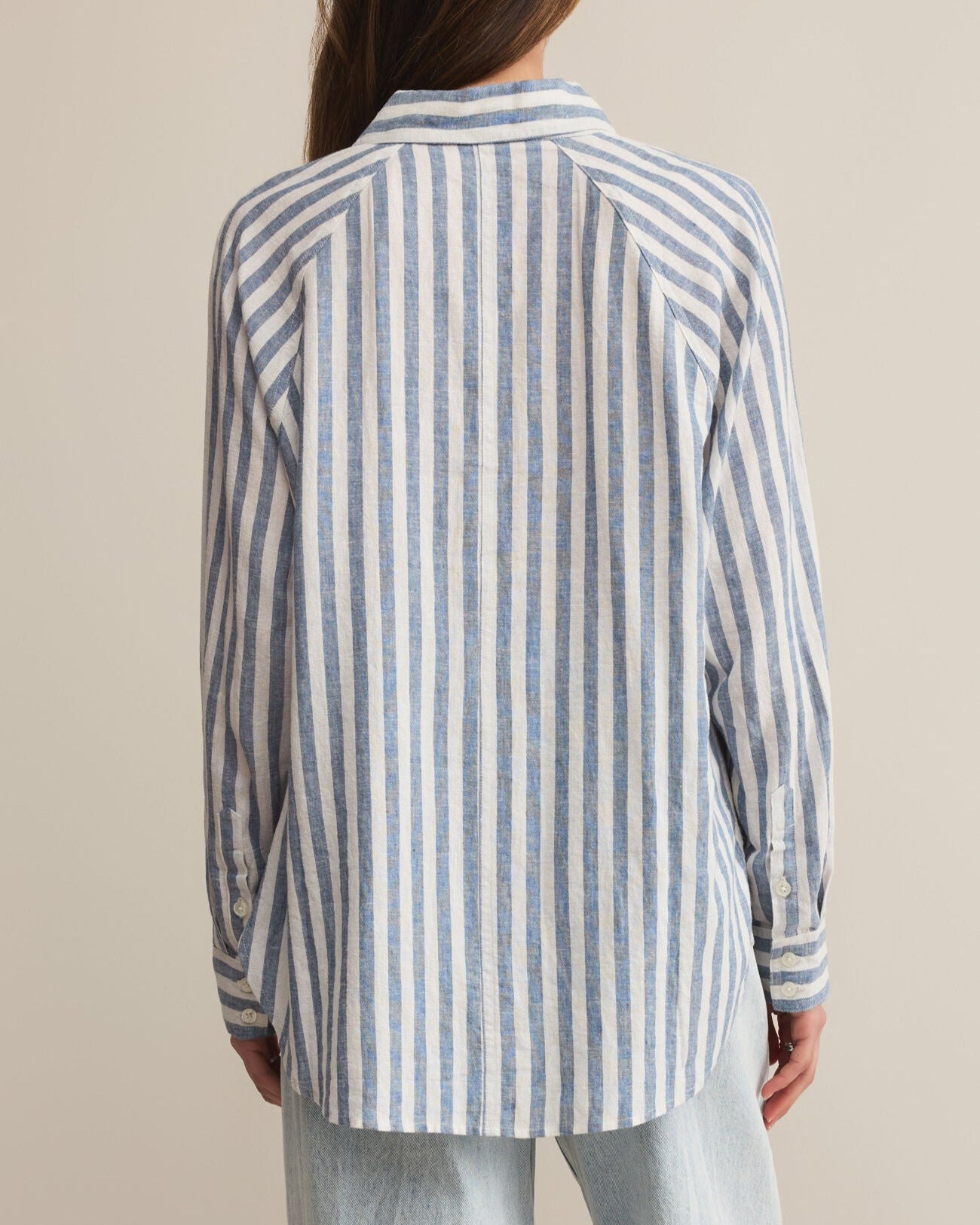 Person wearing a striped shirt with a neutral background