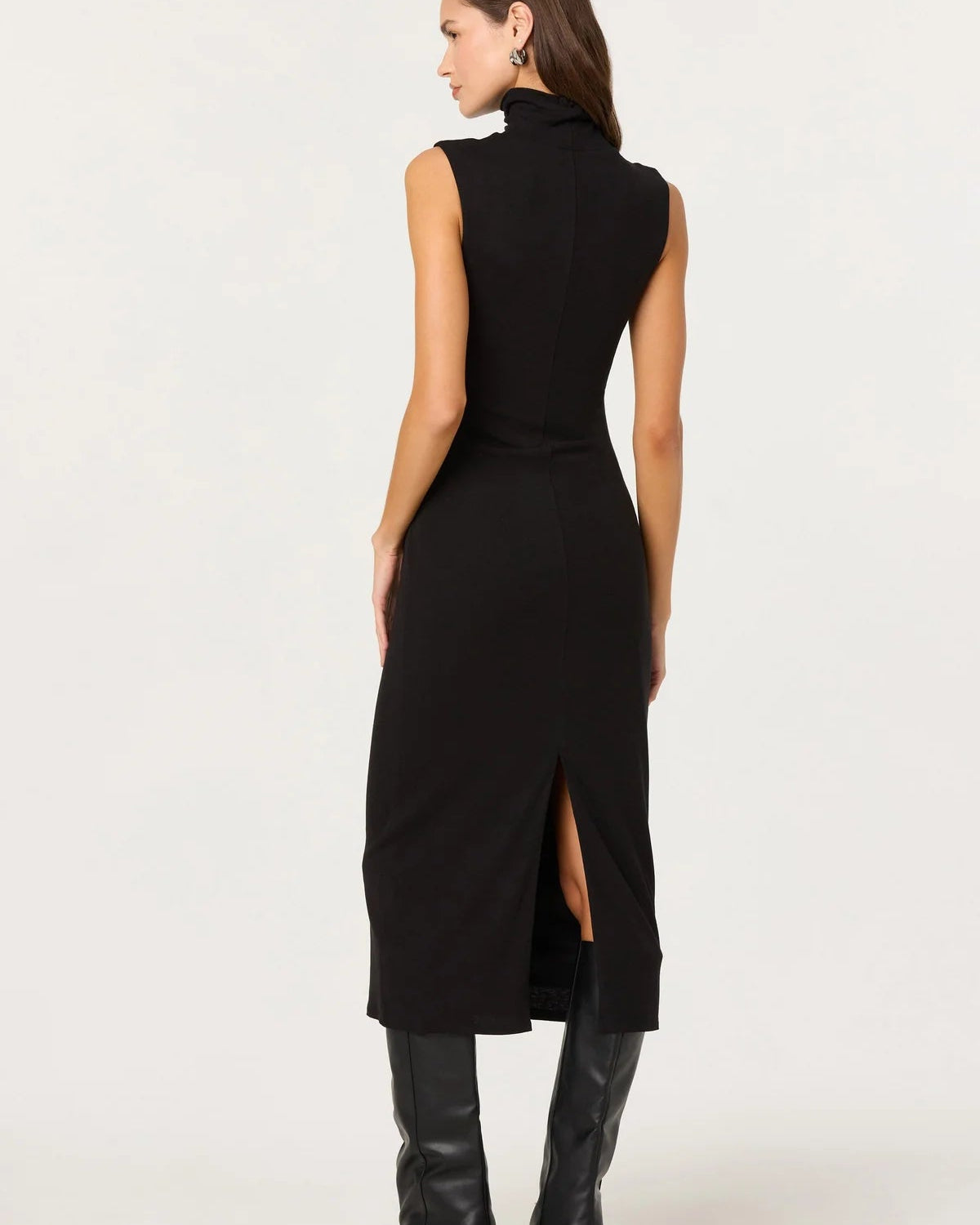 Woman wearing a black sleeveless dress with a slit on a white background