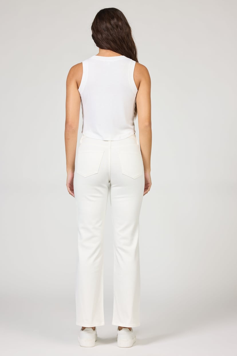 Person wearing a white sleeveless top and pants on a plain background