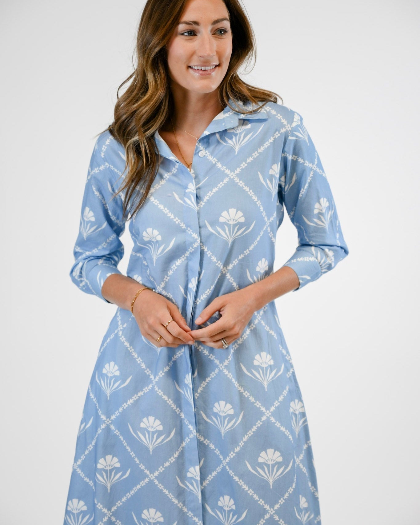 Woman wearing a blue floral dress against a white background