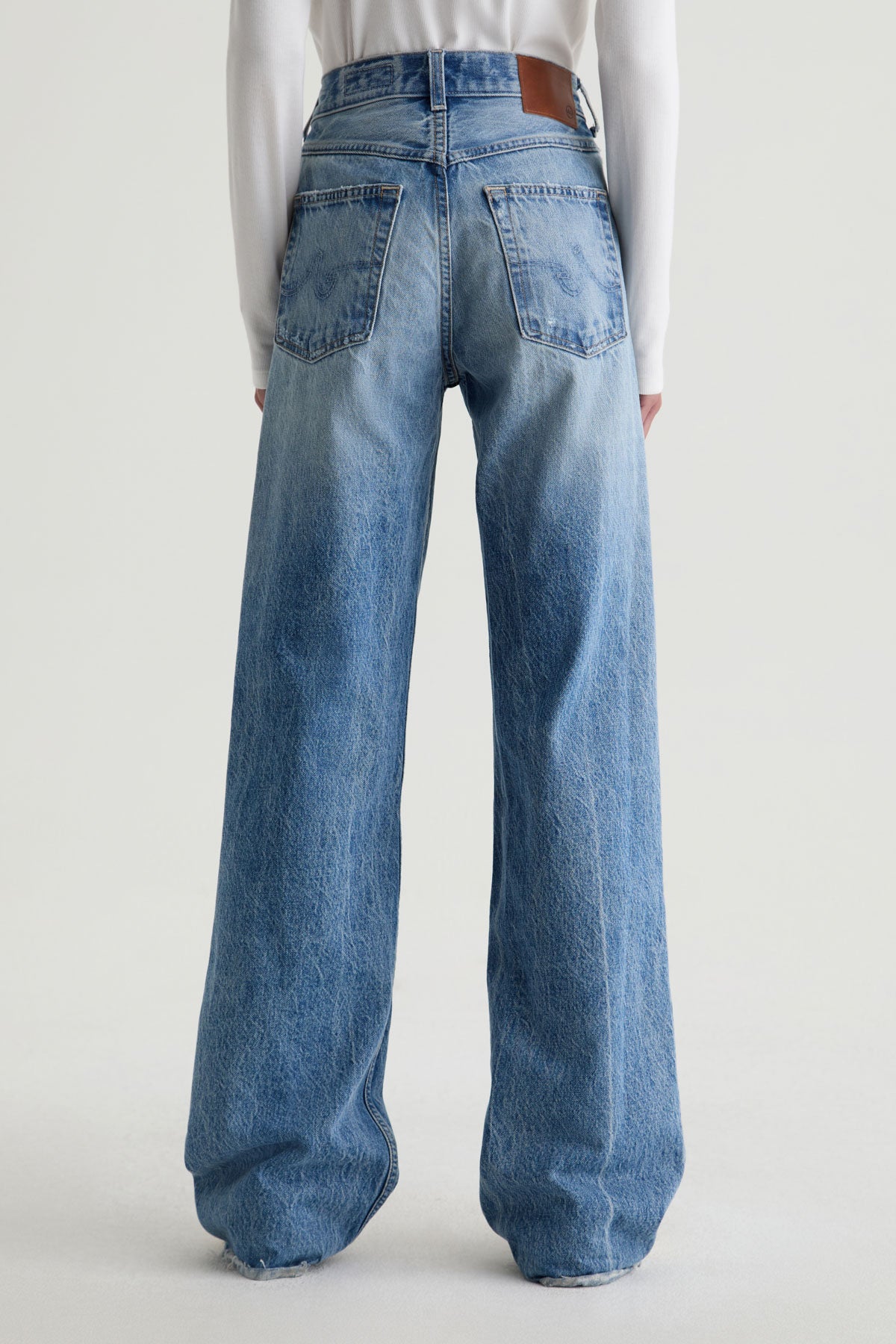 Blue jeans worn by a person on a white background