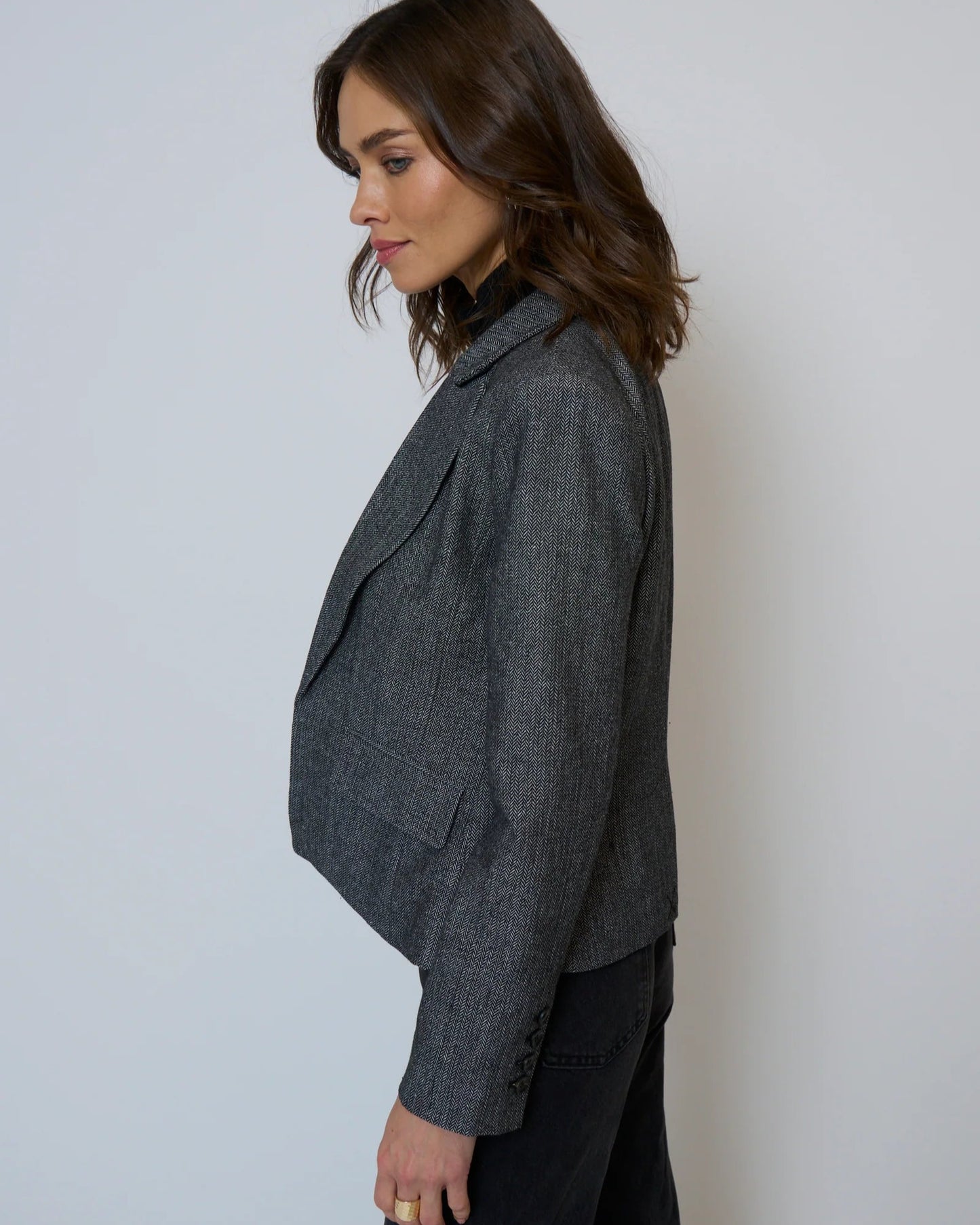 Woman wearing a gray blazer against a plain background