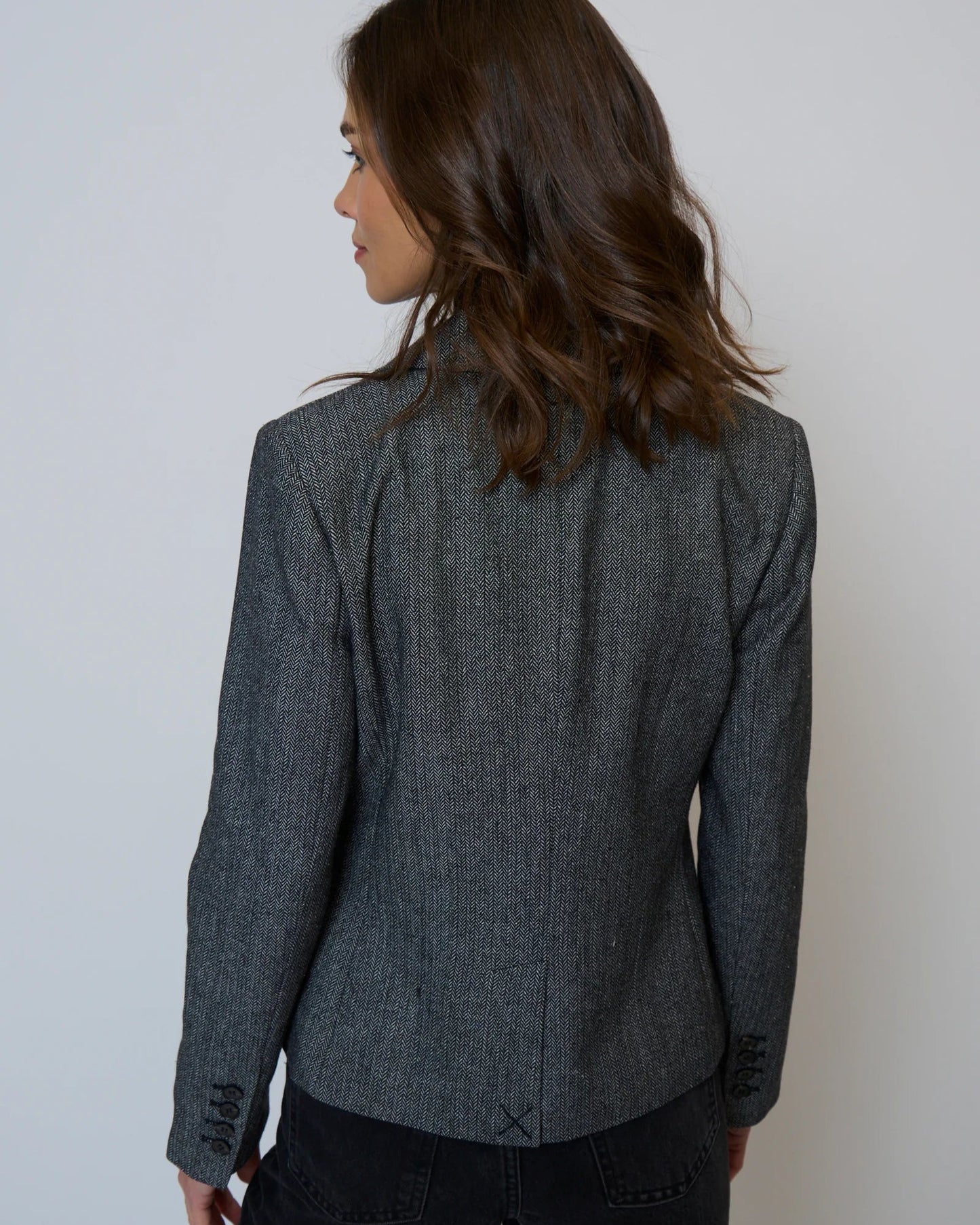 Woman wearing a gray blazer against a white background