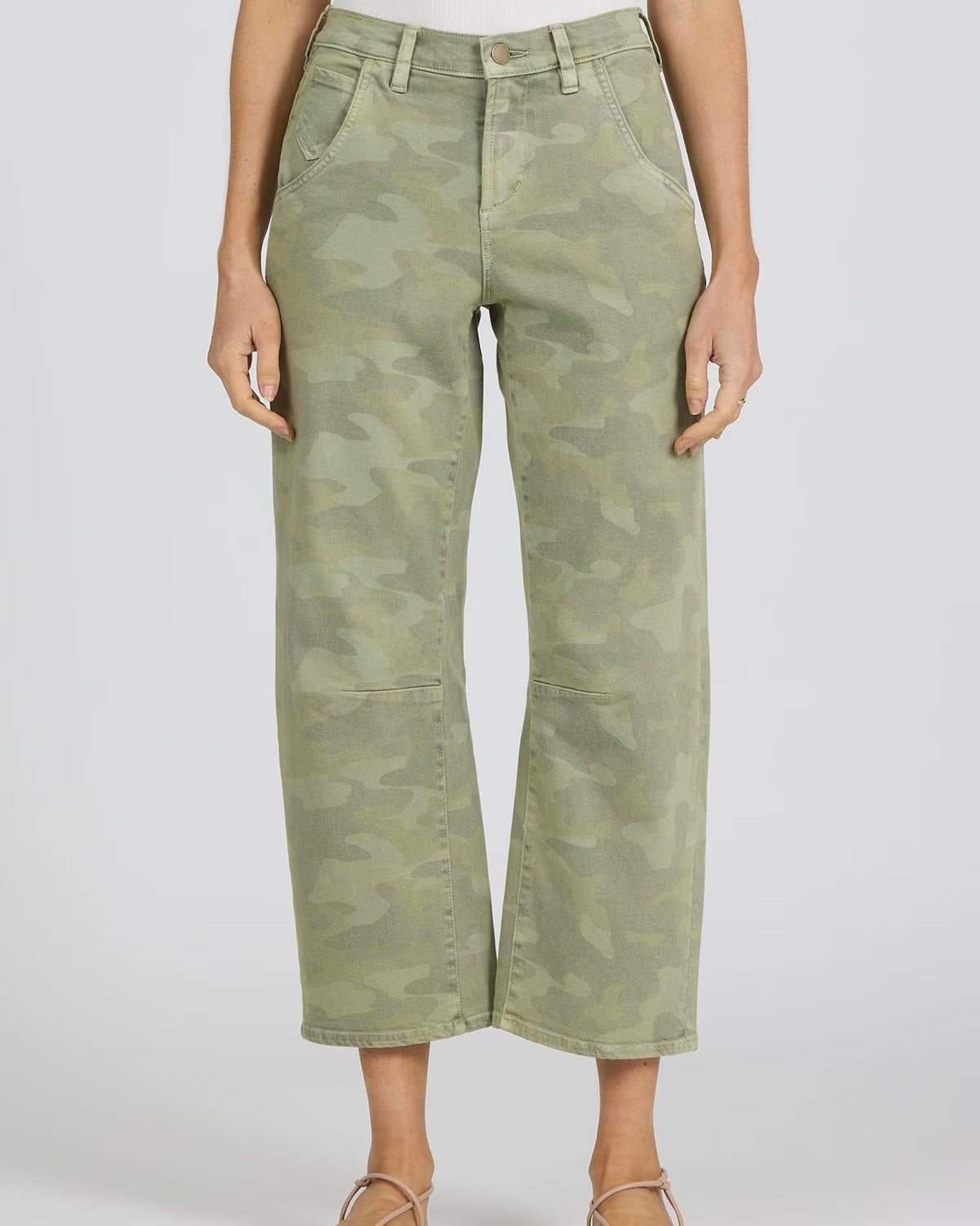 Green camouflage pants worn by a person on a white background