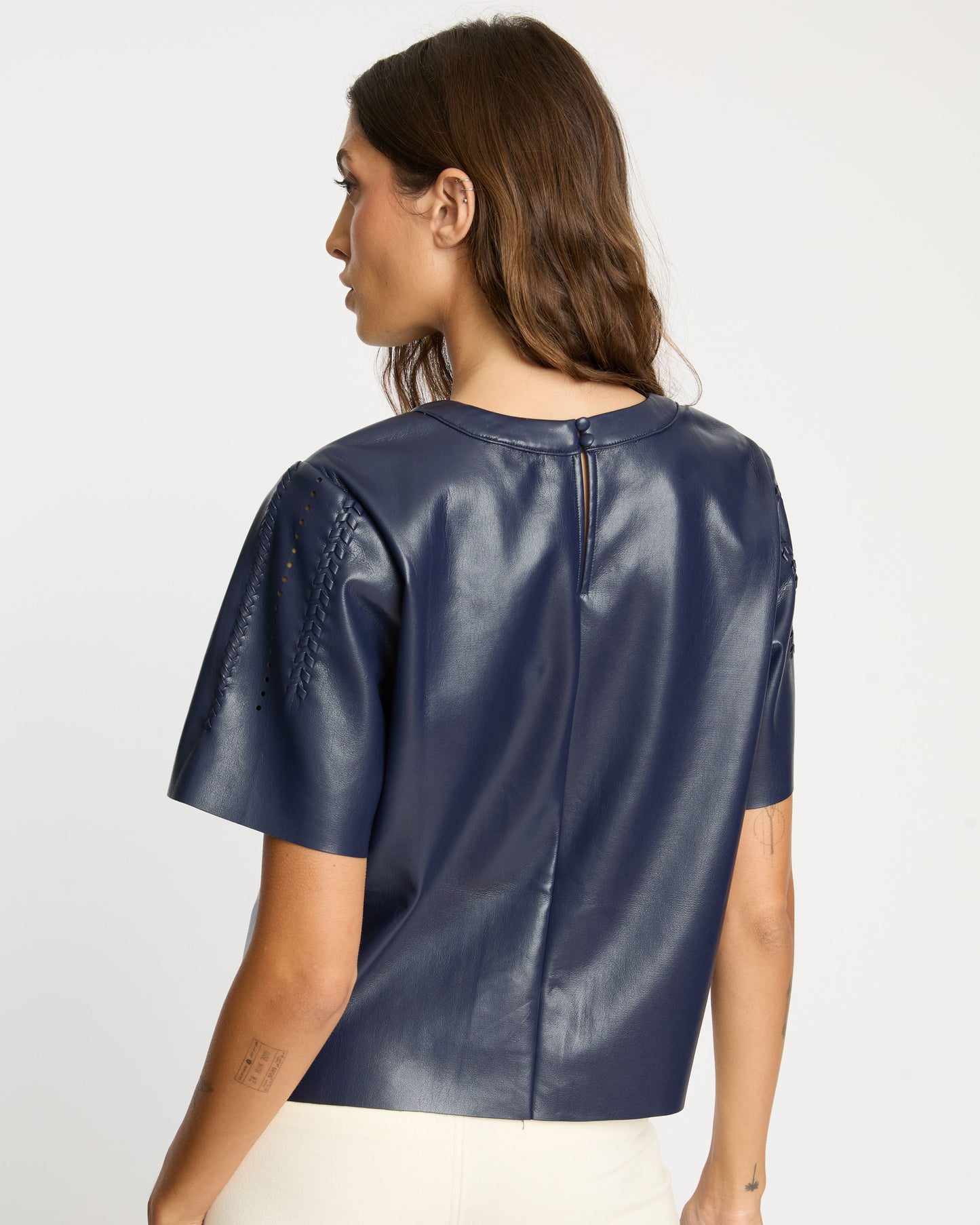 Woman wearing a blue leather top on a white background