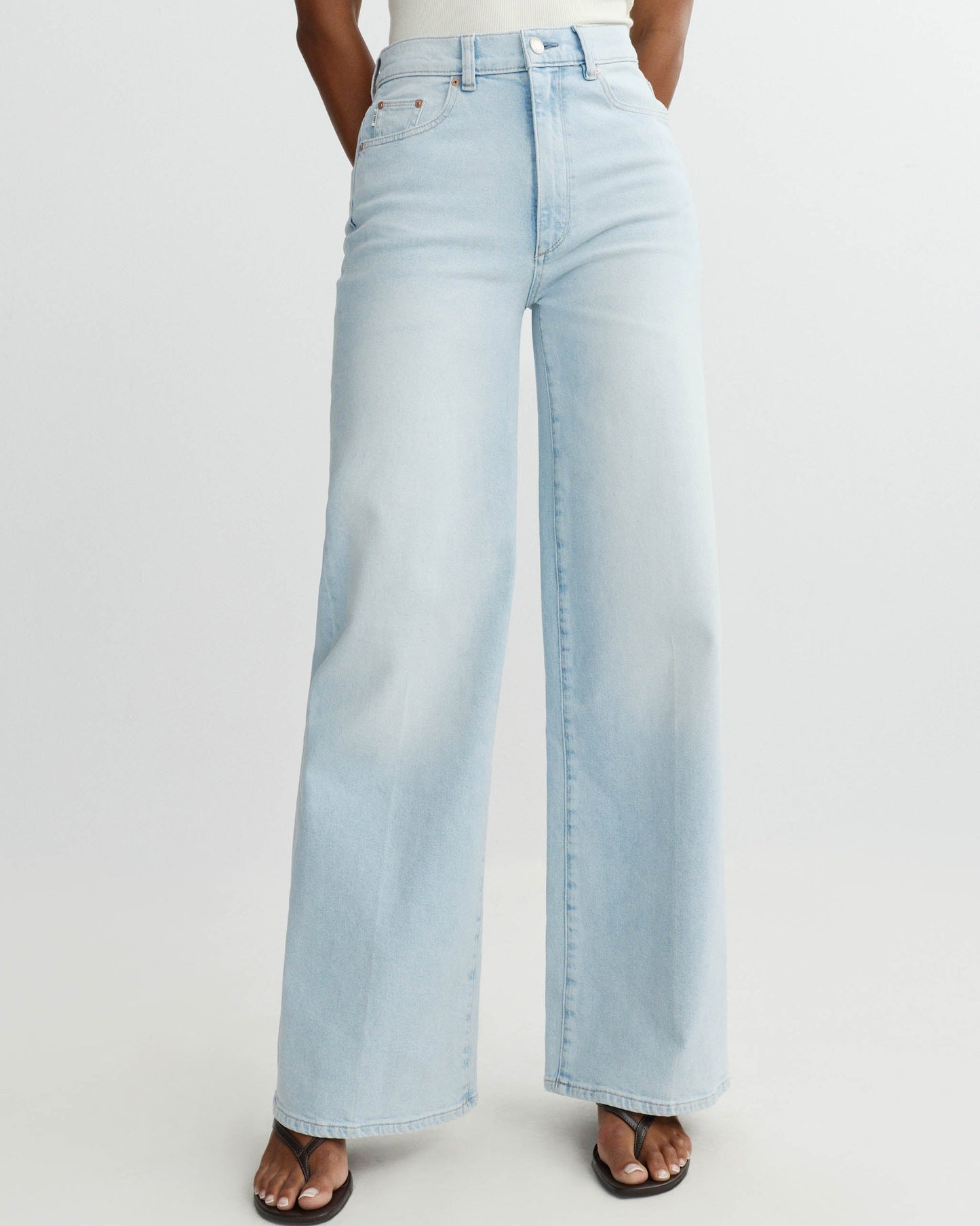 Light blue jeans worn by a person on a white background