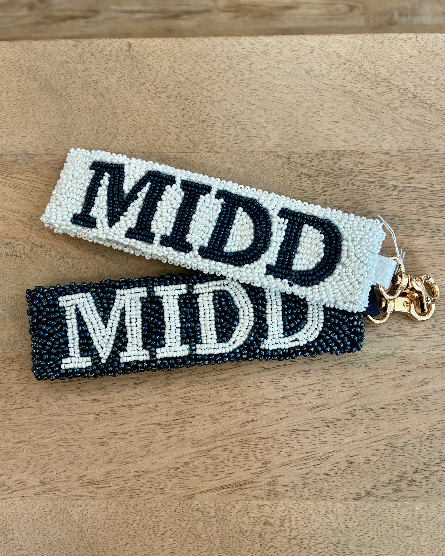 Two beaded keychains with 'MIDD' text on a wooden surface