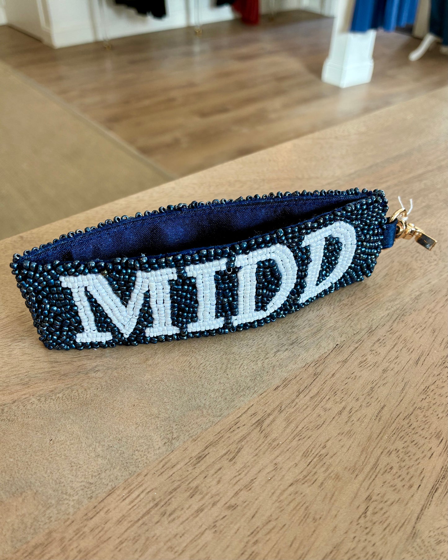 Beaded key chain with 'MIDD' text on a wooden surface