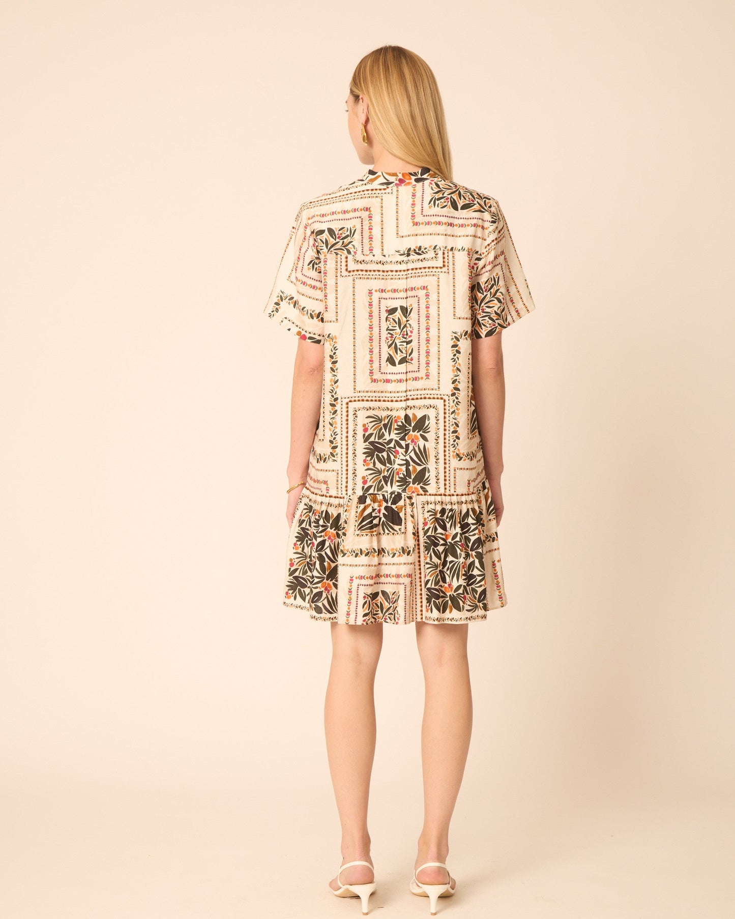 Woman wearing a patterned dress on a beige background