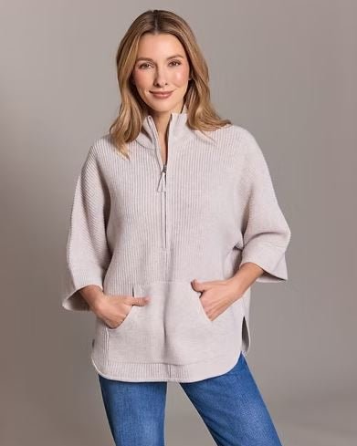 Woman wearing the Alashan Cashmere Merino Bozeman Shaker Half Zip Poncho in Buff against a gray background