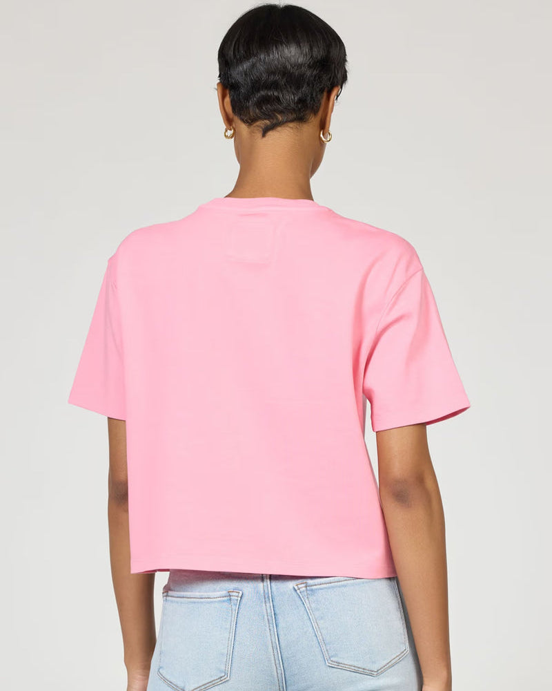Person wearing a pink t-shirt and light blue jeans on a plain background