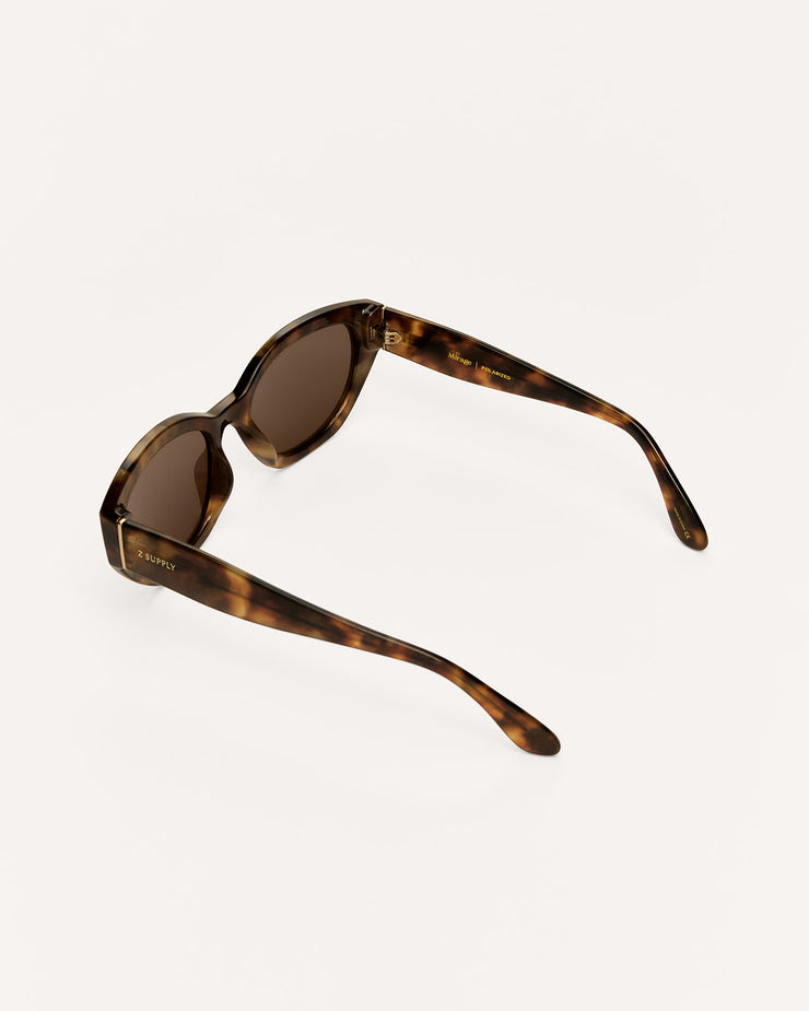 A pair of vintage-style sunglasses with a brown tortoiseshell acetate frame and dark brown lenses, photographed from an elevated angle on a clean, off-white background.