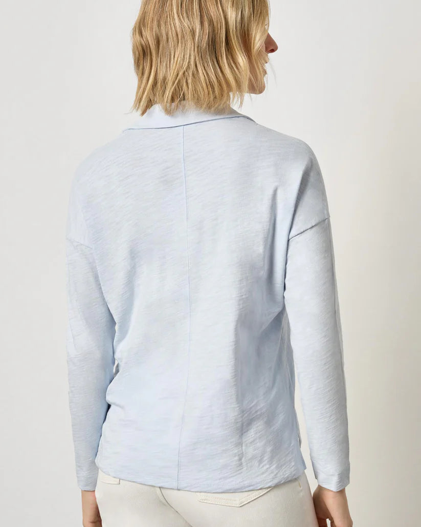 Light blue shirt worn by a person on a plain background