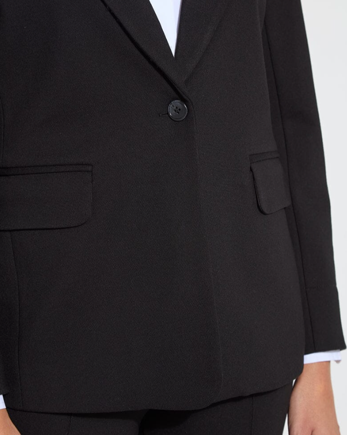 Black suit jacket with a white shirt underneath on a light gray background