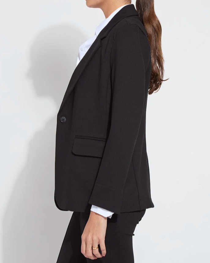 Person wearing a black blazer and black pants on a white background