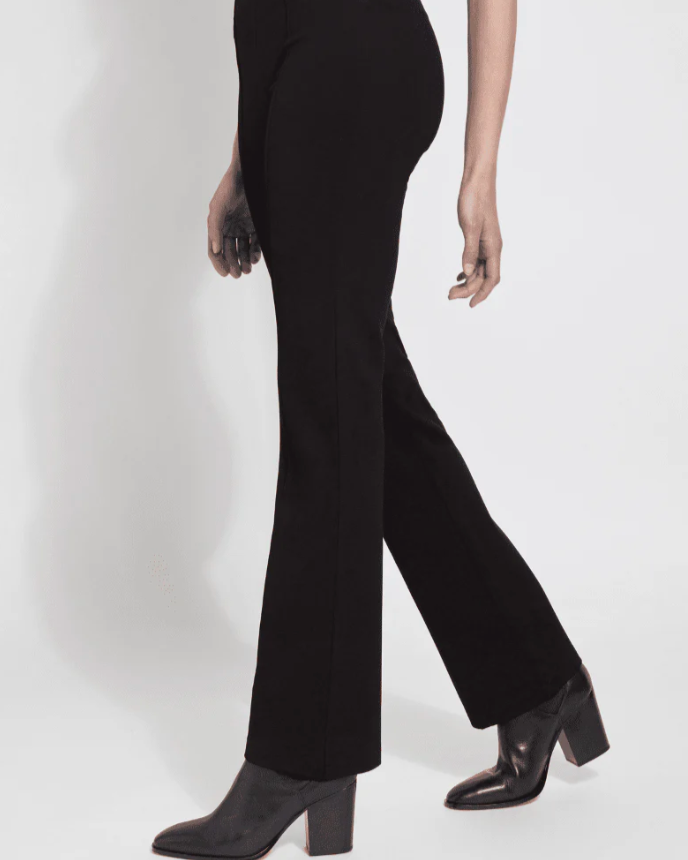 Person wearing black high-waisted pants and black boots on a white background