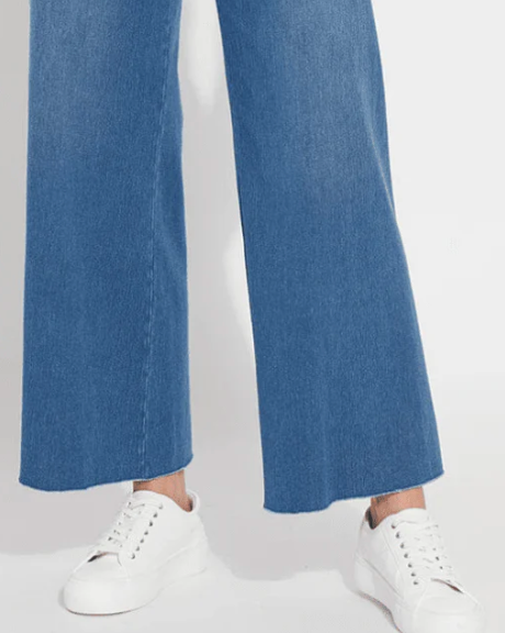 Blue wide-leg jeans worn by a person on a white background