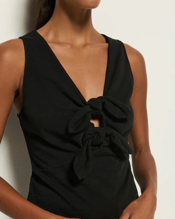 Black sleeveless dress with a knot detail on a neutral background