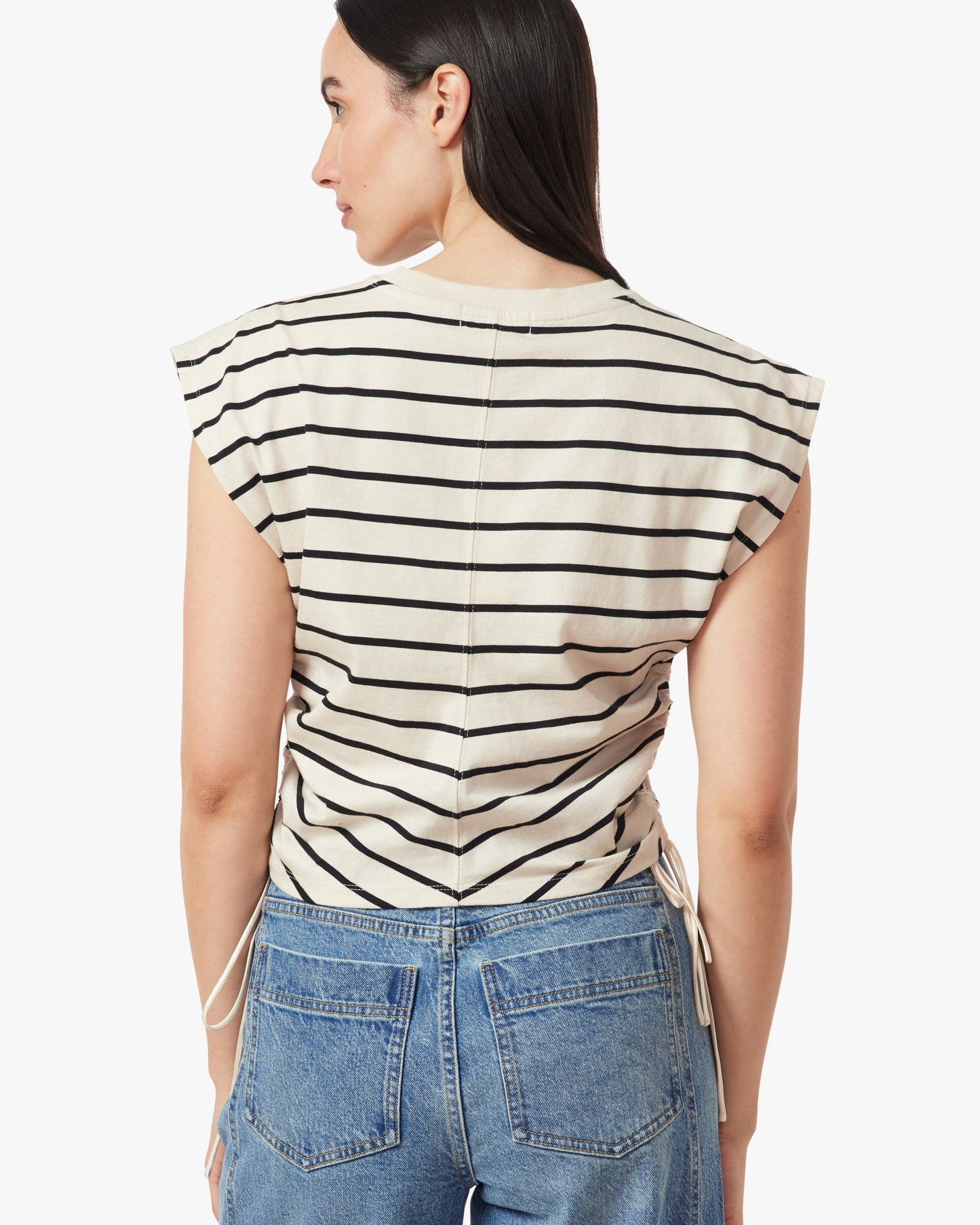Woman wearing a black and white striped top with a plain background