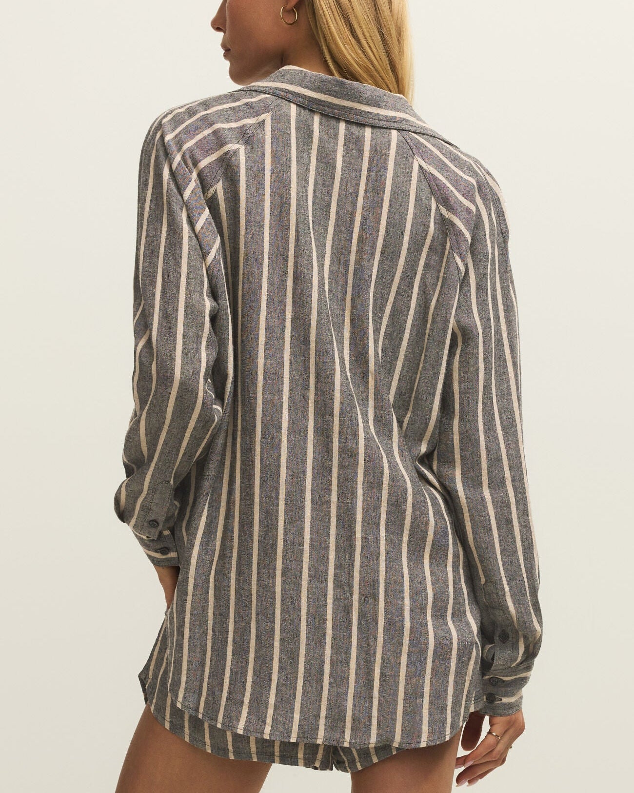 Woman wearing a striped shirt against a plain background