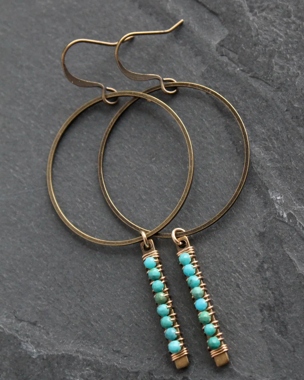Front view of the Wild Balance Telluride Earring in Turquoise resting on a stone background